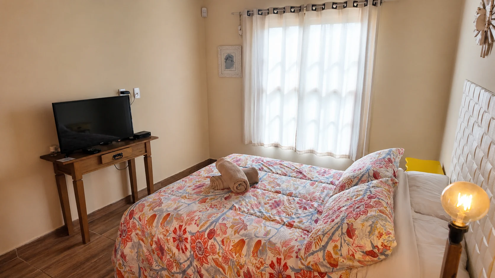 Quarto de chalé com cama estampada e janela ampla