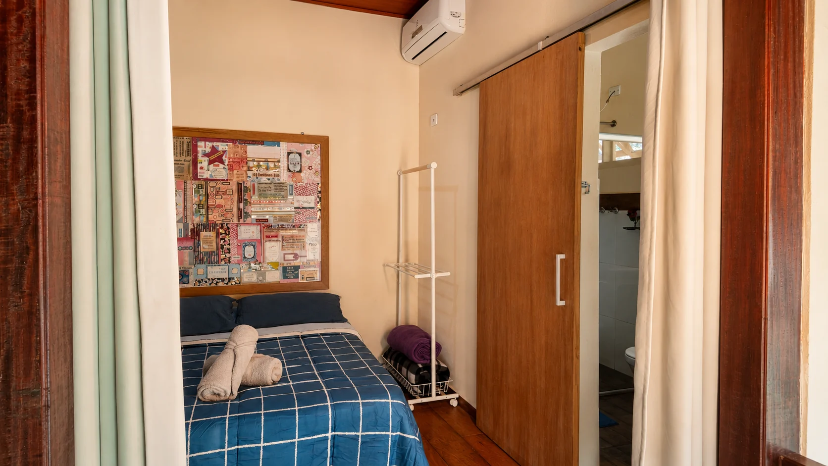 Quarto compacto com cama azul e armário de madeira